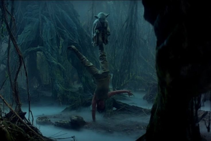 Yoda. A small alien stands on a man's leg.